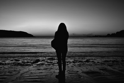 白天轮廓的女人站在海滩上
